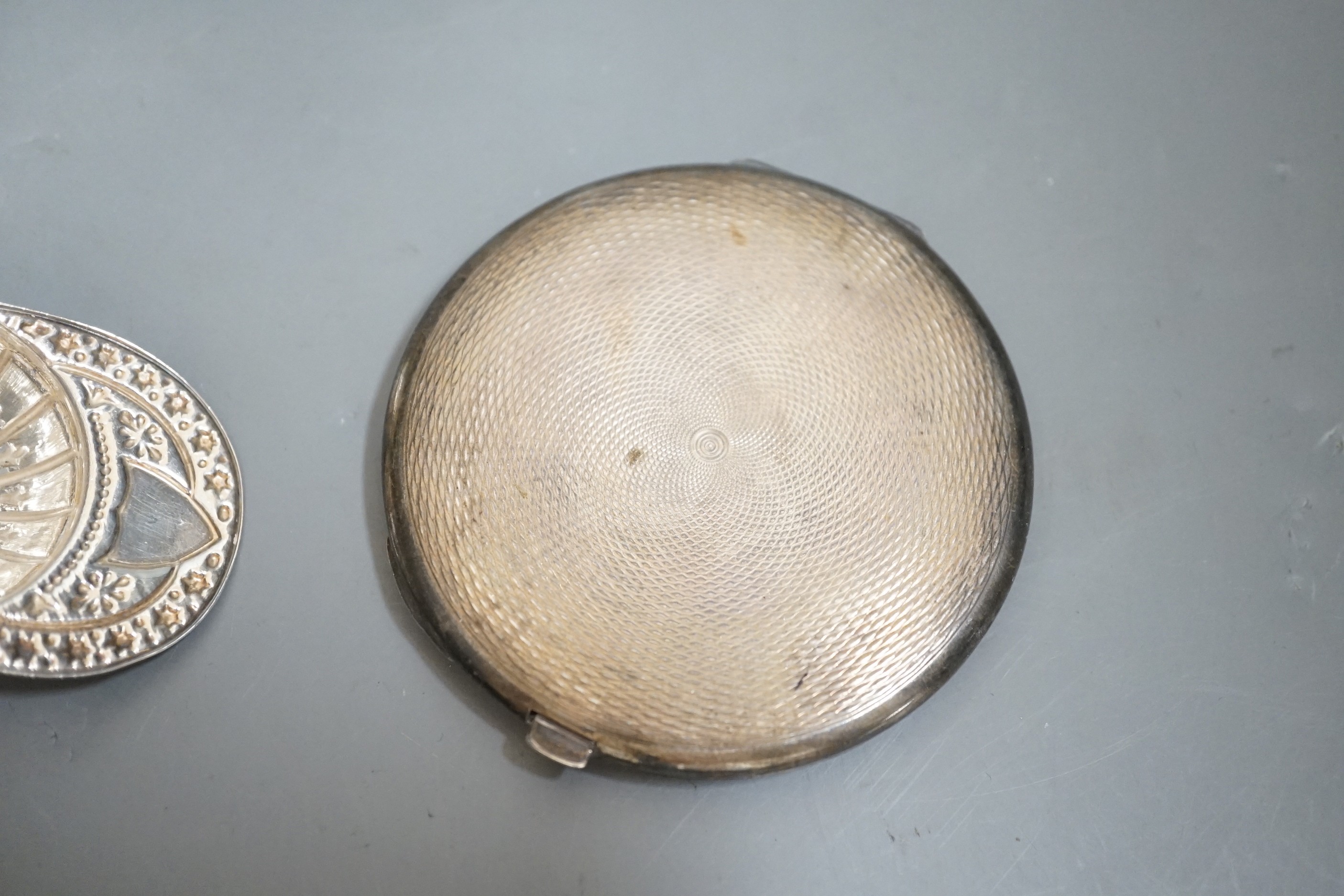 A 19th century continental white metal salt?, with hinged cover, length 93mm, a modern silver jockey cap caddy spoon, a silver and enamel compact and a white metal mounted glass match strike.